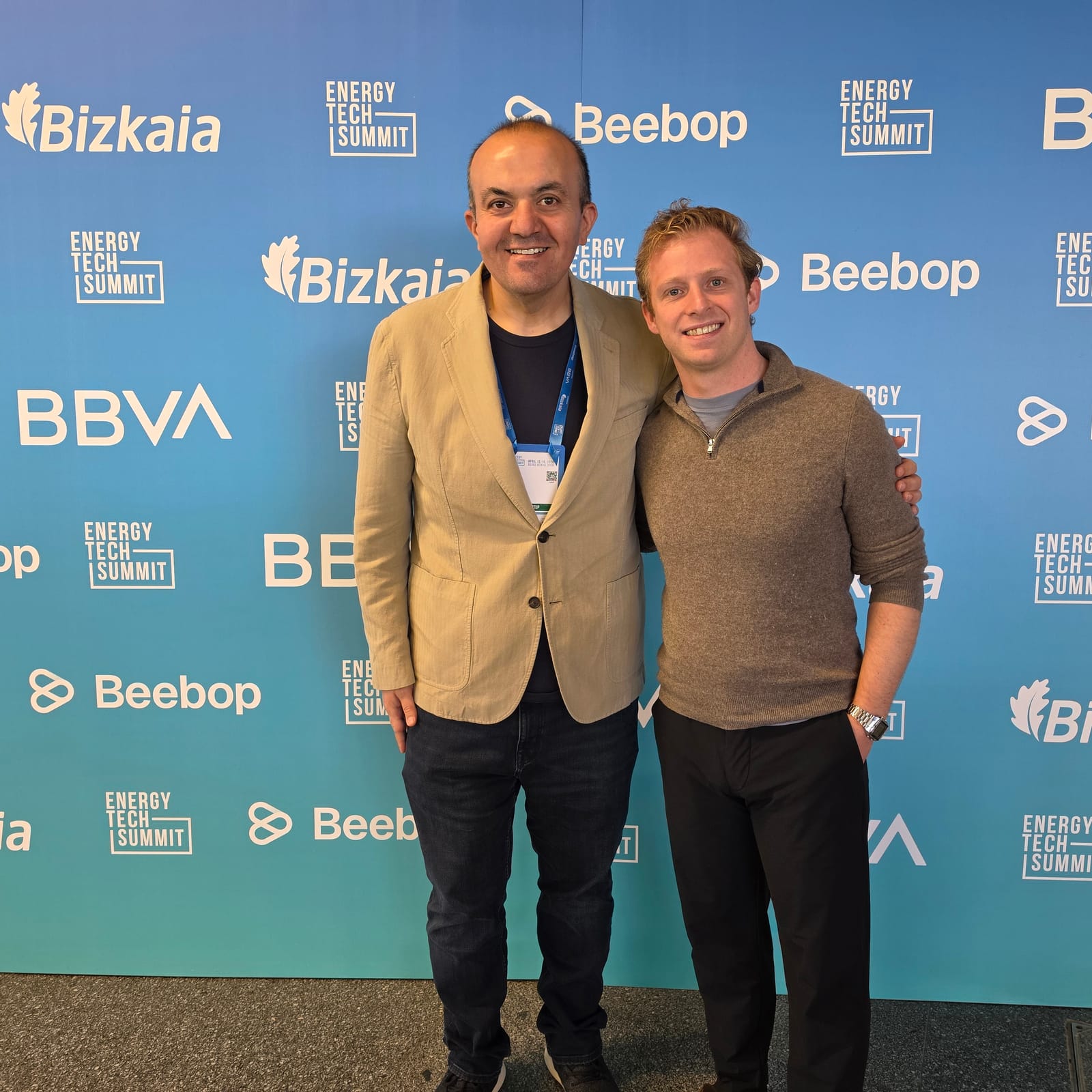 Erdem Celik and Philip Jackson standing in front of the BBVA, Bizkaia, Energy Tech Summit and Beebop photo wall at Energy Tech Summit 2026 in Bilbao
