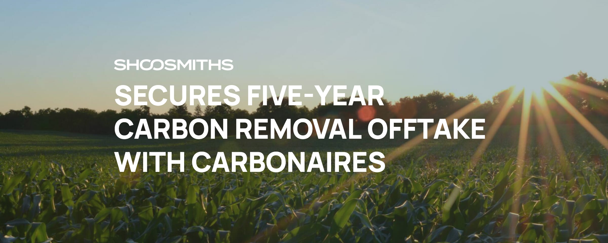 Shoosmiths secures five-year carbon removal offtake with Carbonaires — announcement banner over a sunlit farmland field